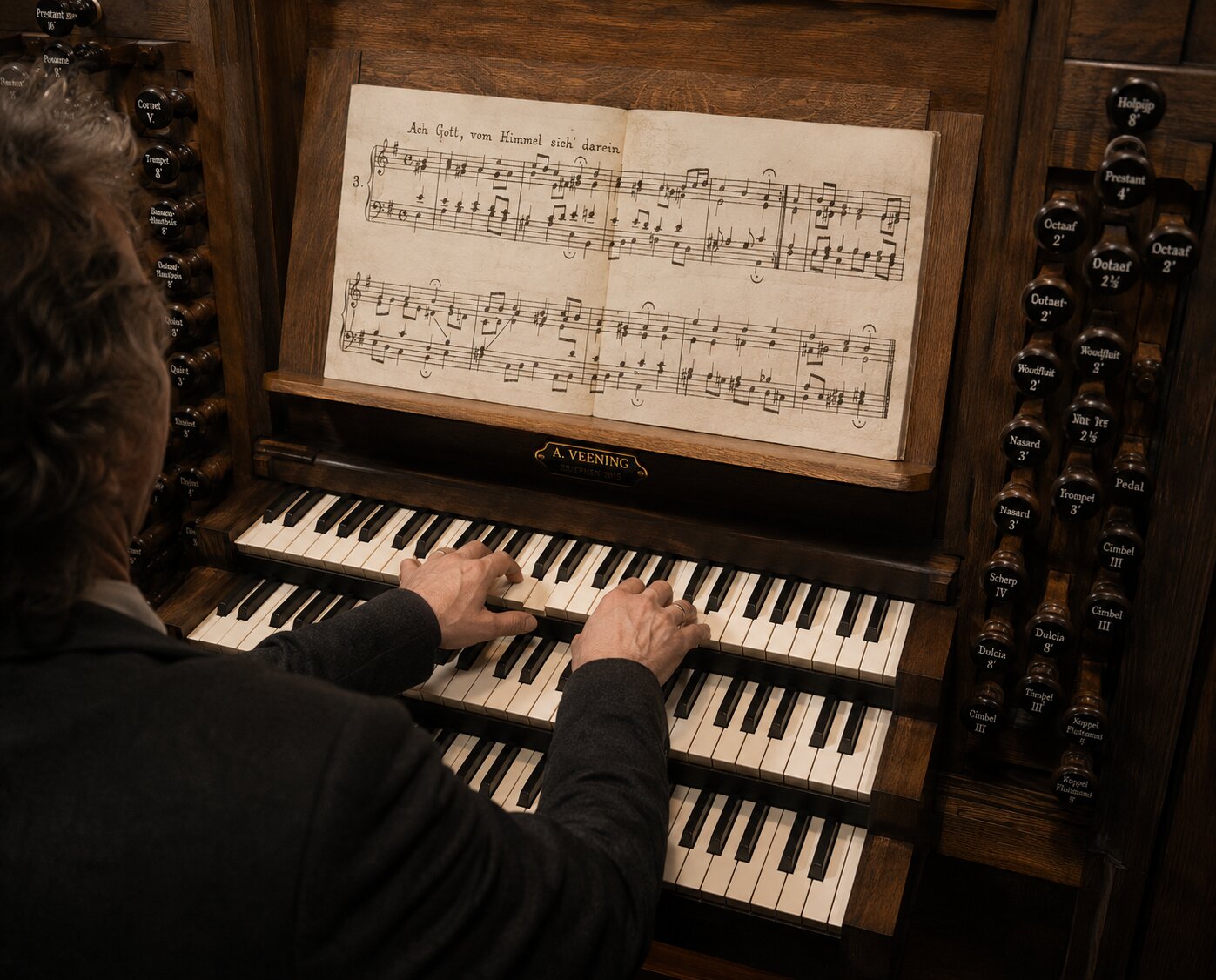 Organist at a pipe organ, hands on the manual, embodying the music through physical presence