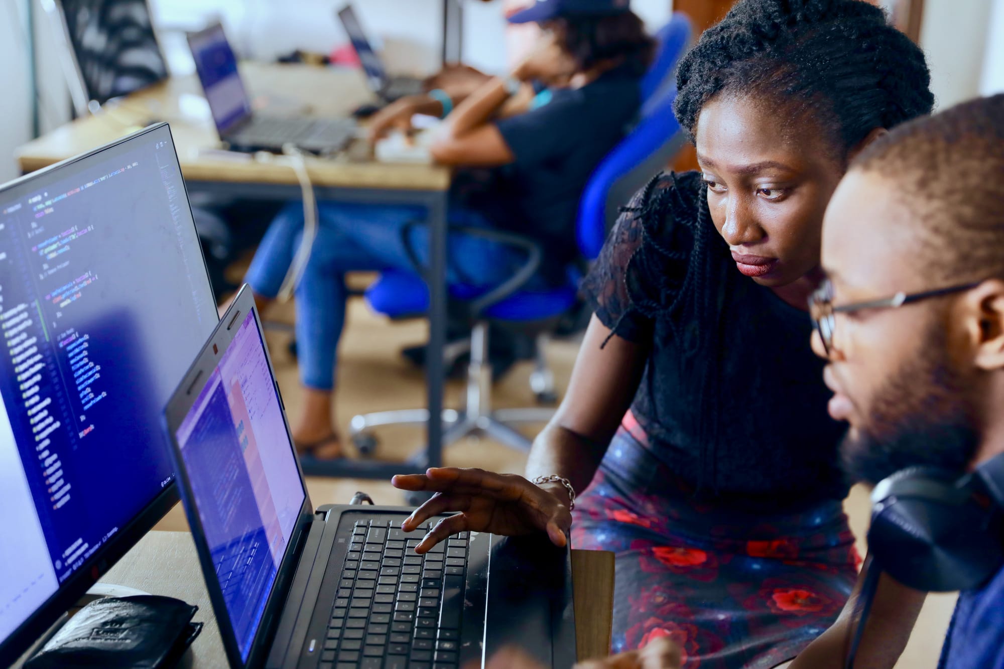 Programmers working at computers, representing the shift to managing AI agents