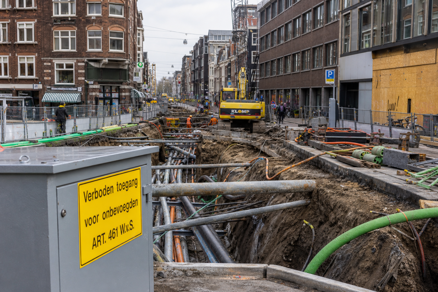 Opengebroken Amsterdamse straat met diepe sleuven vol kabels en leidingen, werkmaterieel en monteurs tussen dichtbebouwde gevels.
