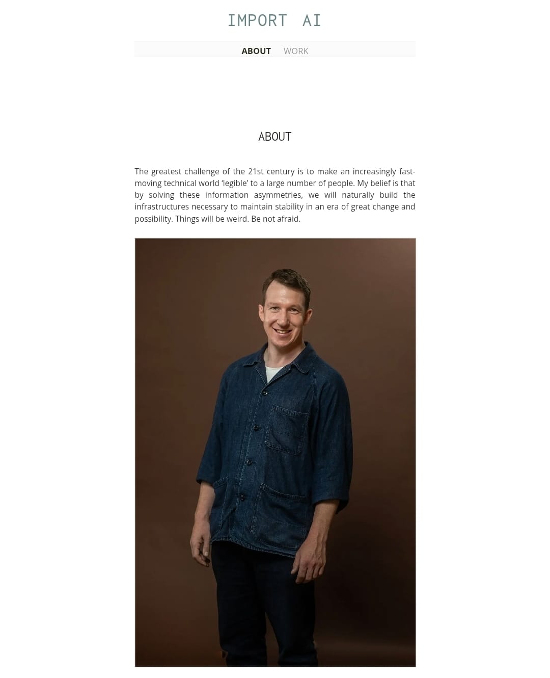 Jack Clark, co-founder of Anthropic, photographed on the About page of his personal website, smiling in a denim shirt against a brown studio background