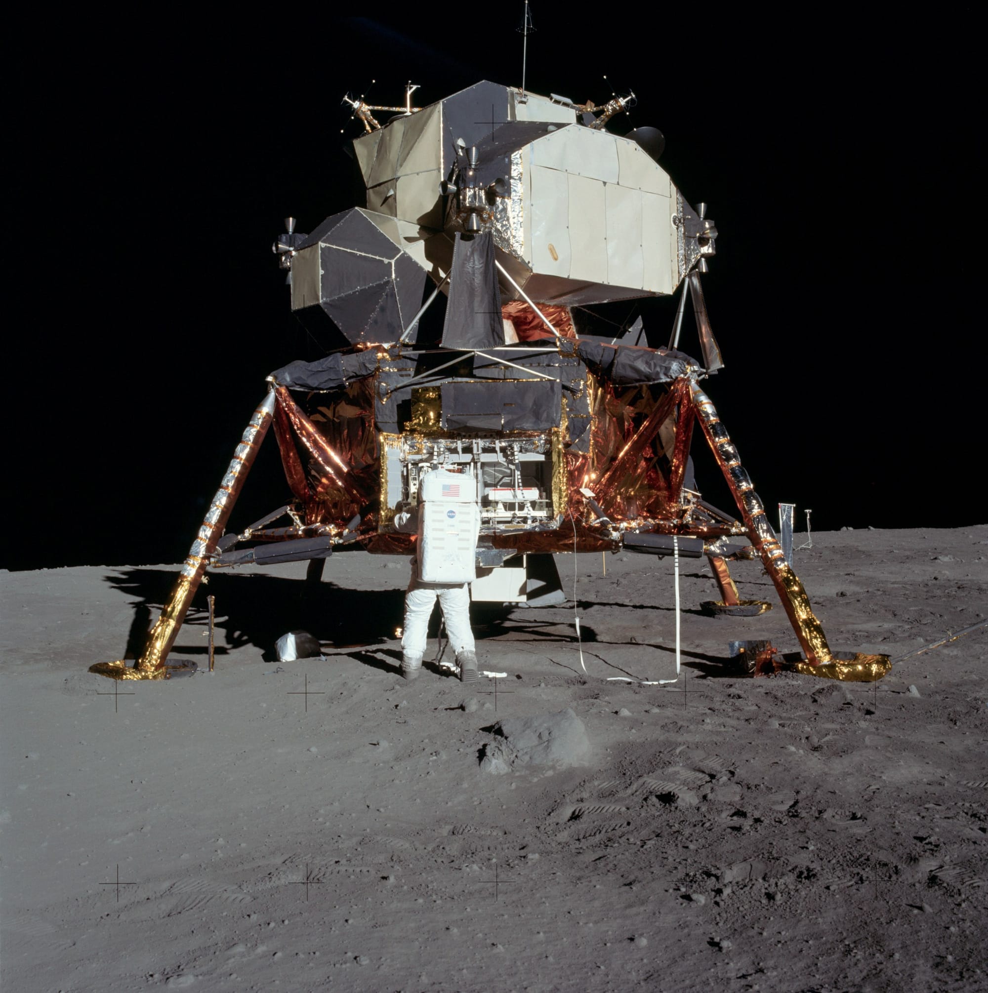 The Apollo 11 lunar module Eagle's descent stage resting on the grey lunar surface, with scientific equipment deployed and the Sea of Tranquility stretching to the horizon