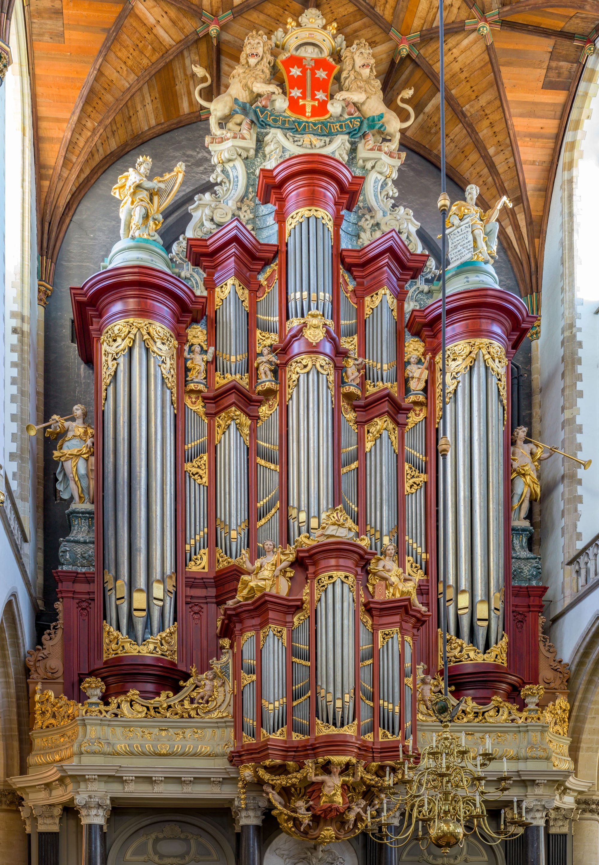 The Christian Muller organ rising inside the Grote of St. Bavokerk in Haarlem, with red casework, gilded ornament and silver pipes.