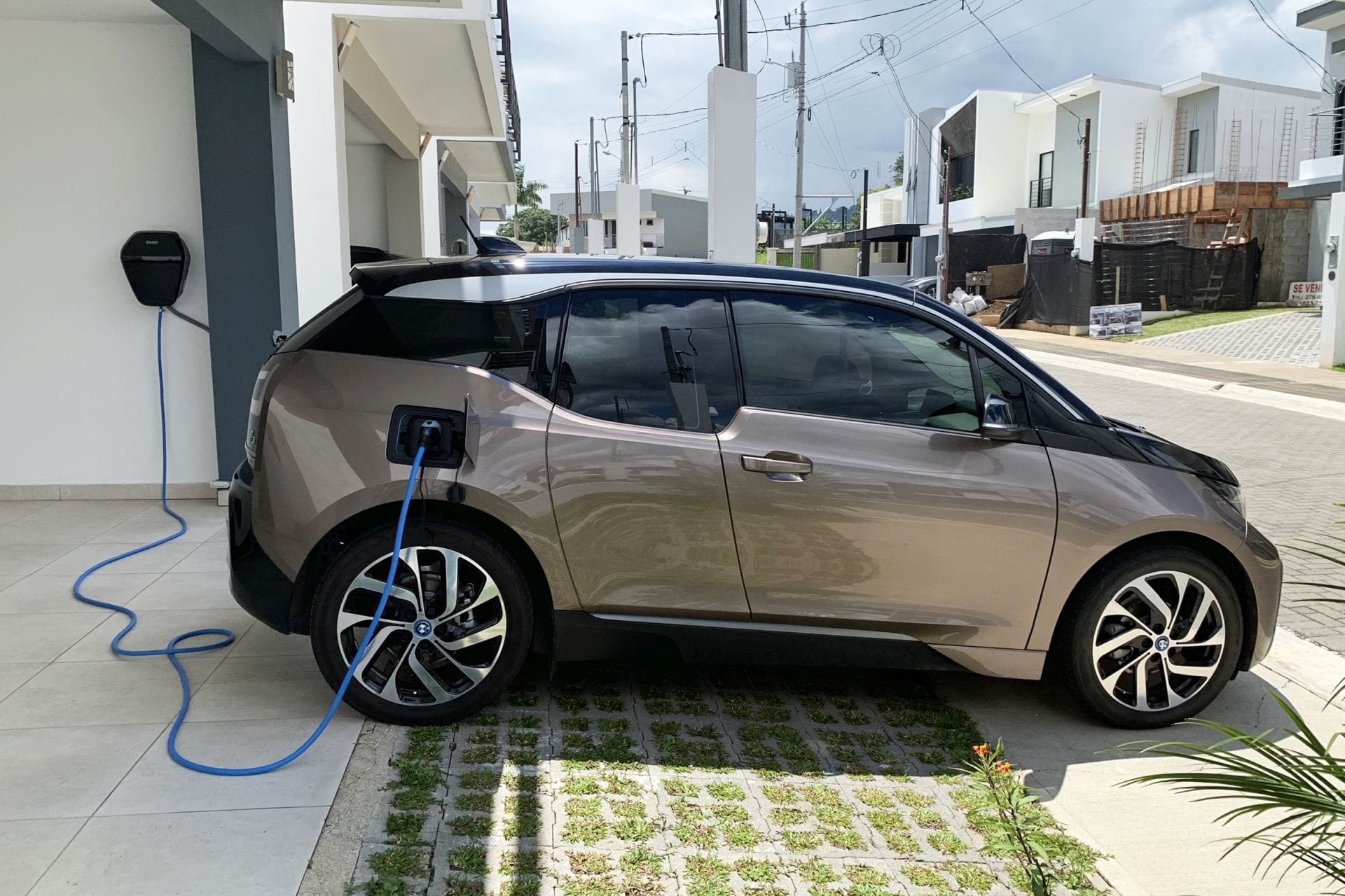 BMW i3 elektrische auto aangesloten aan een witte wallbox lader op een privé-oprit