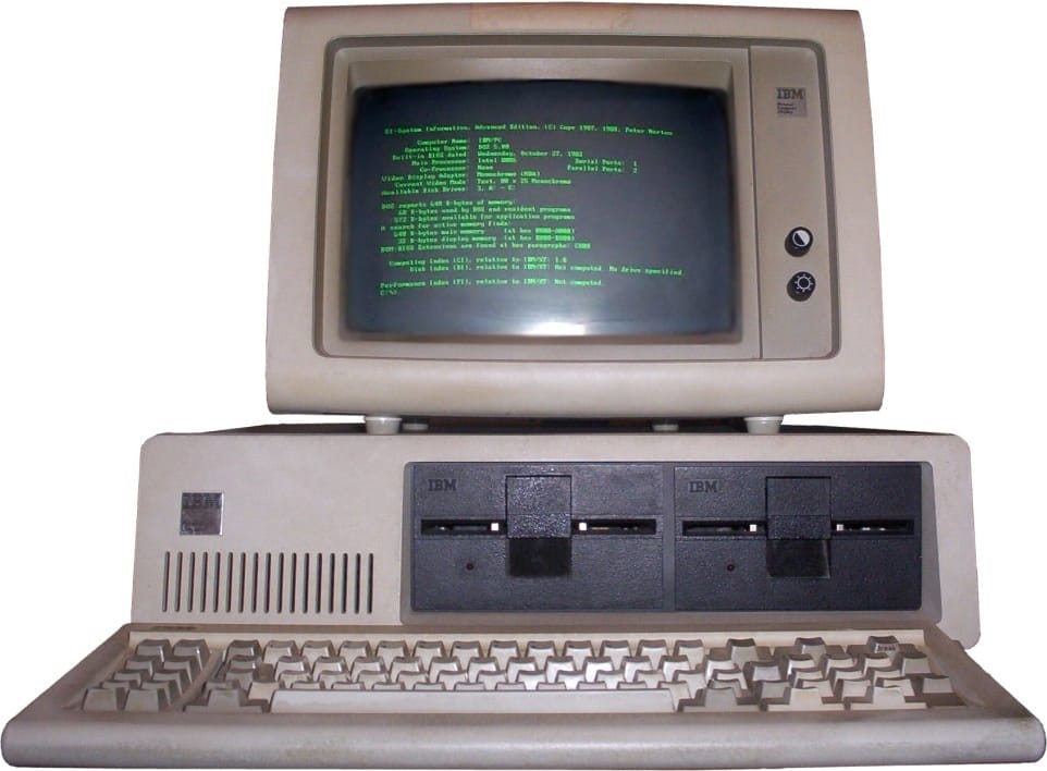 The IBM PC Model 5150 with monitor, keyboard and two floppy disk drives, photographed against a white background