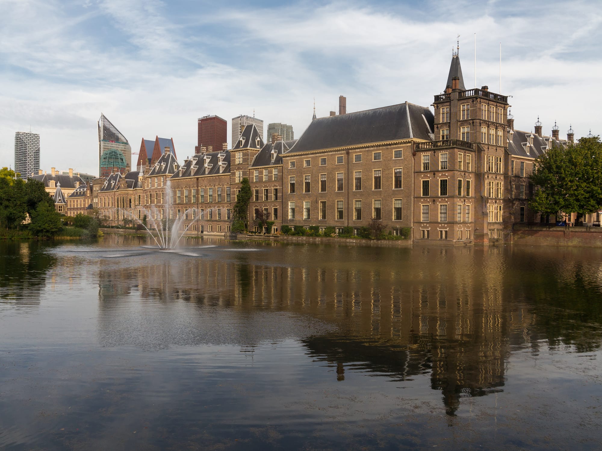 Het Binnenhof in Den Haag met de Ridderzaal en gotische torens, weerspiegeld in het Hofvijver.