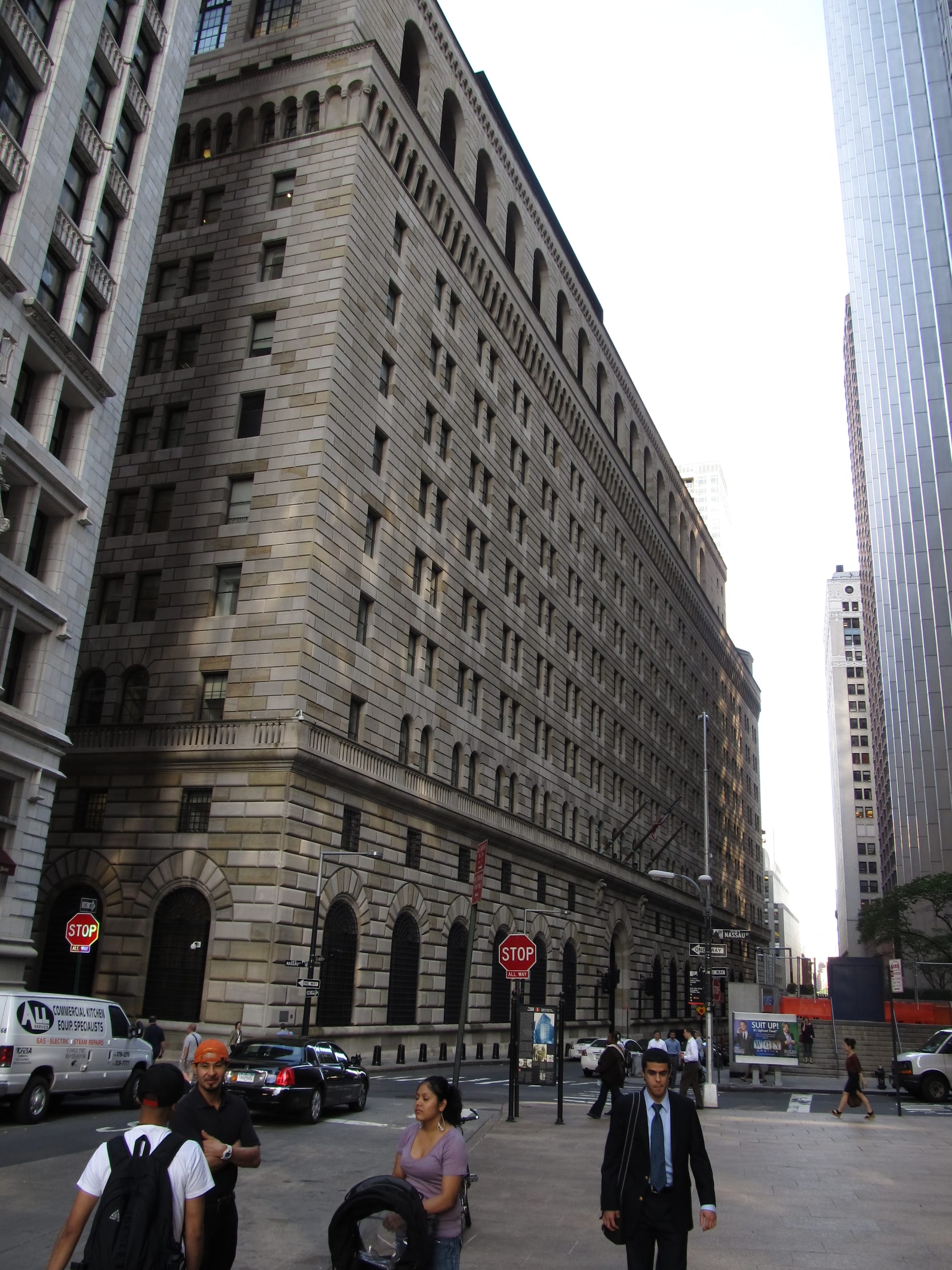 The neoclassical stone facade of the Federal Reserve Bank of New York at 33 Liberty Street in Manhattan, its lower floors barred and fortress-like, with street-level iron railings