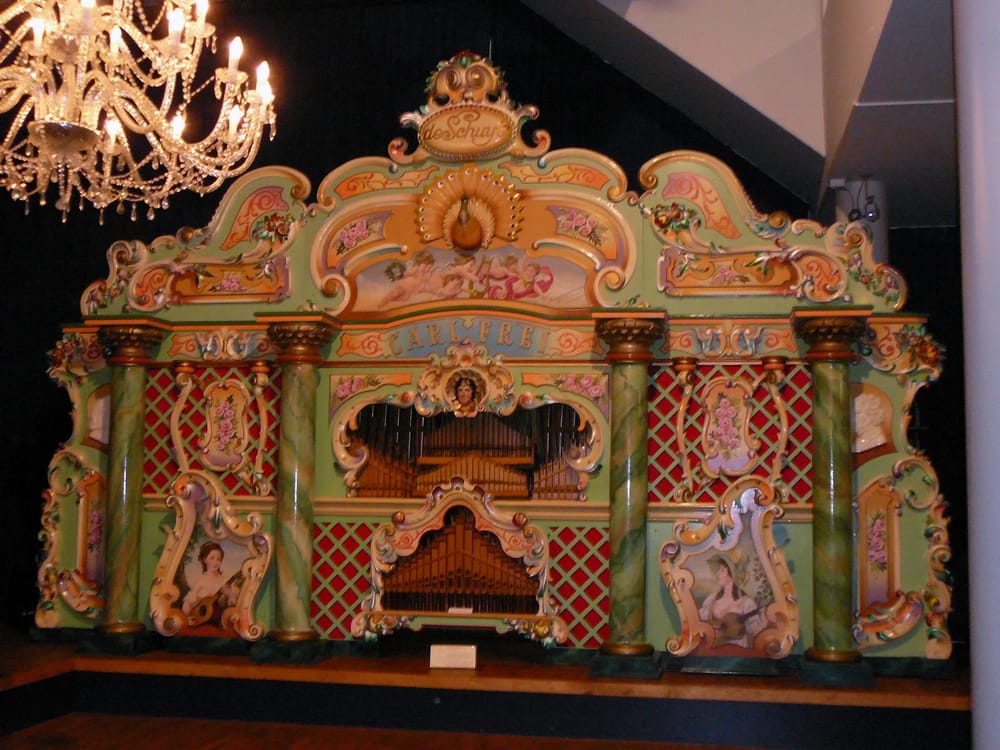 The ornate facade of the Mortier De Schuyt fairground organ at Museum Speelklok in Utrecht, with decorative painted panels and organ pipes